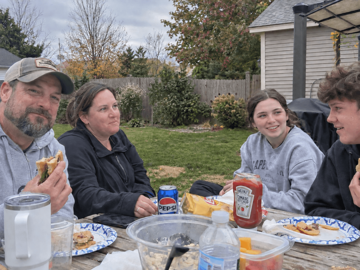 A family having lunch in their ordinary back yard